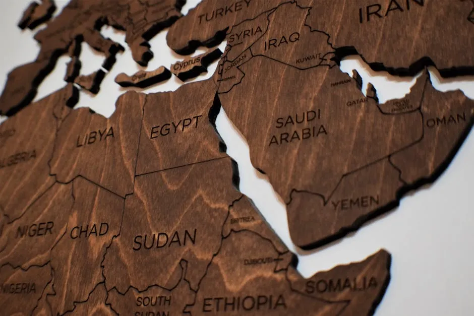 Wooden map of the world with text labels for some countries in the Middle East including Yemen.